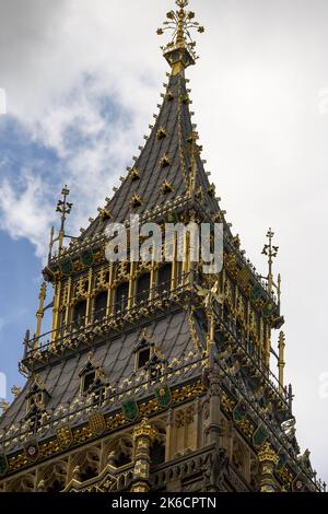 Nahaufnahme der Spitze des Elizabeth Tower London UK mit verwickeltem gotischen Stil mit vergoldeten Schilden. Stockfoto