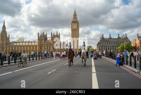 2 montierte Polizisten der Metropolregion fahren über die Westminster Bridge London mit dem Palace of Westminster im Hintergrund.Tag 1Queen liegt im Staat. Stockfoto