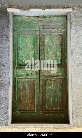 Alte grüne verwitterte Holzdoppeltür, überfällige Wartung Stockfoto