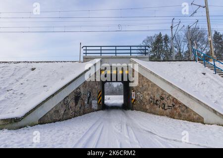 Enge Passage unter den Bahngleisen im Dorf Rogow in der woiwodschaft Lodzkie in Polen Stockfoto