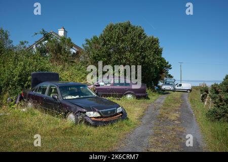 Inishbiggle, County Mayo, Irland, 07-14-2019. Kaputte Autos mit Müll werden achtlos auf der Insel zurückgelassen. Stockfoto