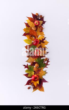 Dekoratives Herbstmuster mit Kopierfläche auf weißem Hintergrundtisch, Zusammensetzung aus getrockneten Blättern, Äpfeln, Haselnüssen, Walnüssen und Eicheln, flaches Lay, Oben Stockfoto