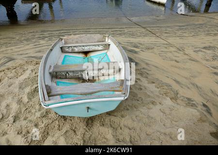 Winziges Ruderboot aus Holz auf dem Sand Stockfoto