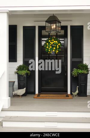Veranda des traditionellen Hauses mit Zitronenkranz an der Eingangstür Stockfoto