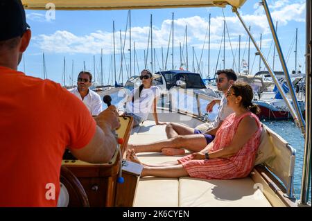 Ein Charterboot mit Touristen, das den Hafen von St. Maria di Leuca zu den Höhlen entlang der Küste in Richtung Adria abfährt. Apulien (Apulien), Italien. Stockfoto