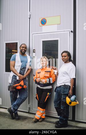 Ganzkörperportrait mit männlichen und weiblichen Bauarbeitern auf der Baustelle Stockfoto