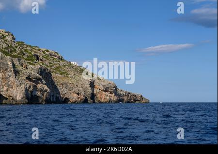 Ein kleines, weißes Haus, das auf einer abfallenden Klippe an der Küste von Apulien (Apulien) in der Nähe von Santa Maria di Leuca, Italien, liegt. Stockfoto