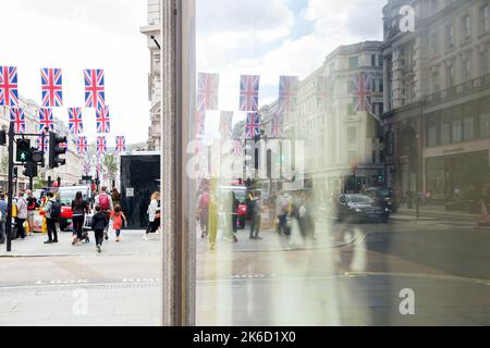 Die Dekoration der Unionsflagge spiegelt sich auf einem Bild an einer Wand in der Regent Street im Zentrum von London vor den Feierlichkeiten zum Platin-Jubiläum wider. Stockfoto