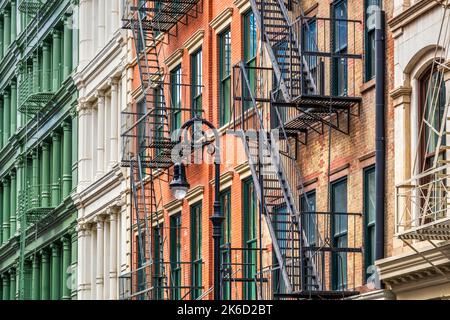 Alte bunte Gebäude mit Metall-Feuertreppen Leitern, East Village, Manhattan, New York, USA Stockfoto