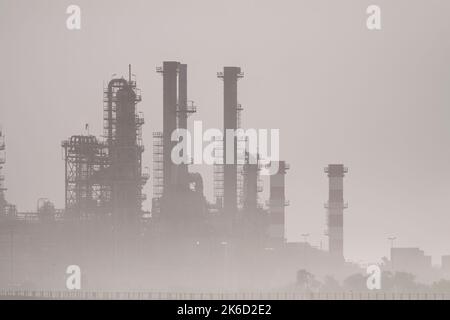 Teil einer großen Ölraffinerie inmitten von Smog und Morgennebel. Foto von 2010. Stockfoto