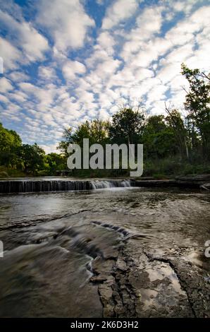 Popcornwolken dominieren den Himmel über den Felsvorsprüngen auf Praimee Creek im DesPlaines River Fish & Wildlife Refuge, will County, Illinois Stockfoto