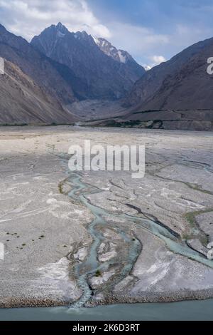 Türkisfarbener milchiger Fluss, der von der Hindu Kush Range auf der afghanischen Seite in den Panj fließt, in der Nähe von Langar, Wakhan Corridor, Gorno-Badakshan, Tadschikistan Pamir Stockfoto