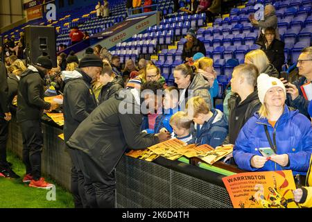 Ein Spieler der Rugby League-Mannschaft von Papua-Neuguinea signiert ein Poster für Kinder bei der WM, das im Halliwell Jones Stadium begrüßt wird Stockfoto