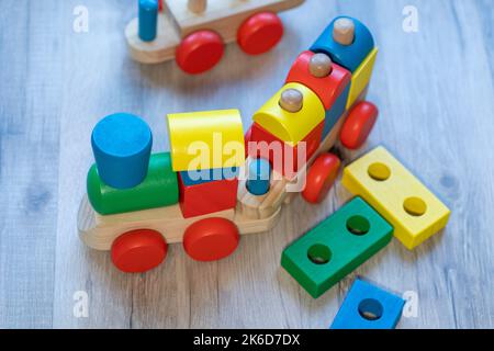 Holzspielzeugzug mit bunten Blöcken auf grauem Holzboden Stockfoto