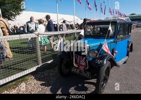 Blue Austin 7, geschmückt mit Union Jack-Flaggen zur Feier des hundertsten Jahrestages der Markteinführung des Fahrzeugs im Jahr 1922, geparkt im Fahrerlager, Revival Meeting, Goodwood Stockfoto