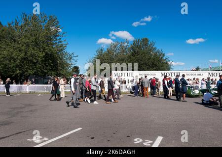 Sir Jackie Stewart führt besondere Gäste in historischen Kostümen im Assembly-Bereich beim BARC Revival Meeting auf der Goodwood Motorrennstrecke, Großbritannien Stockfoto