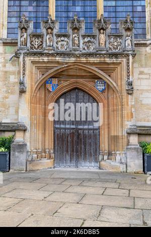 England, Oxfordshire, Oxford, Magdalen College, St. Johns Quad, Holztor unter dem Westfenster der College-Kapelle mit Wappen und Statuen von Johannes dem Täufer, Edward 1V, St. Maria Magdalena, St. Smwithun und William Waynflete. Stockfoto