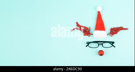 Rentier mit roter Kugelnase, Geweih, Weihnachtsmannhut und Brillen, fröhliche weihnachtskarte Stockfoto