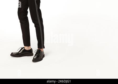 Junger Mann in elegantem Anzug, schwarze Schuhe stehen isoliert auf weißem Hintergrund Stockfoto