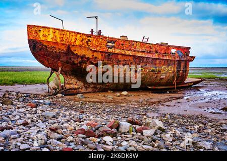 Ein rostiger Schiffswrack im Schlamm des Walney-Kanals auf Roa Island, Cumbria, England, Großbritannien Stockfoto