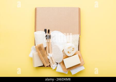 Null Abfall mit natürlichen Self Care Zubehör auf Gelb. Bambus Zahnbürsten, handgemachte Seife Shampoo Bars, Wattestäbchen Pads, Hygiene Produkte luffa, Ansicht von oben, selektiver Fokus Stockfoto
