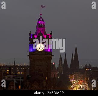 Edinburgh, Schottland, Großbritannien. 13.. Oktober 2022. Make 2.s Count, gegründet von der Mutter Lisa Fleming aus Edinburgh, hat eine Kampagne gestartet, um das mangelnde Bewusstsein und die Unterstützung für den unheilbaren Krebs zu unterstreichen. Wahrzeichen in ganz Großbritannien werden mit einer Kombination von Farben beleuchtet, die mit der Wohltätigkeitsorganisation verbunden sind, um das Bewusstsein zu schärfen, darunter die Edinburgh Camera Obscura, der Granton Gas Tower und das Balmoral, an dem die Gebäude teilnehmen, die mit rosa, violetten und blauroten Lichtern beleuchtet werden. Das Balmoral öffnete am 15 1902. Oktober offiziell seine Pforten als North British Station Hotel. Quelle: Arch White/alamy Live News Stockfoto