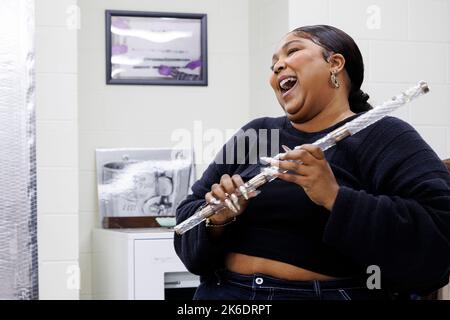 Washington, Vereinigte Staaten von Amerika. 26. September 2022. Die Pop-Sängerin und Songwriterin Lizzo lacht, als sie eine 200 Jahre alte Kristallflöte während einer Tournee durch die Music Division in der Library of Congress am 26. September 2022 in Washington, D.C. probiert.die Flöte gehörte einst dem vierten Präsidenten der Vereinigten Staaten, James Madison. Quelle: Shawn Miller/Library of Congress/Alamy Live News Stockfoto