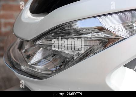 Frontscheinwerfer mit Windschutzscheibe eines Motorrads. Motorrad, Seitenansicht, Nahaufnahme. Stockfoto
