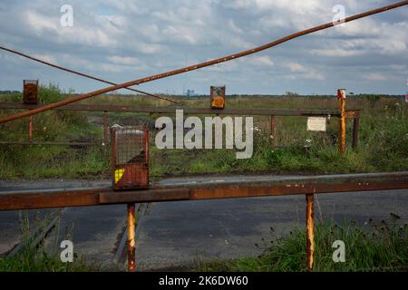 Überreste einer alten Eisenbahnkreuzung für den Torftransport durch Bord na Móna. In der Ferne das Torfkraftwerk von Edenderry. Stockfoto