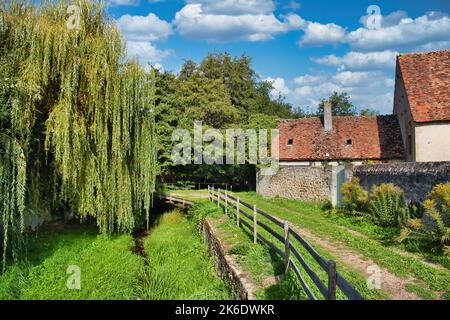 Kleiner Fluss und Wanderweg entlang der Stadtmauer der mittelalterlichen Stadt Moulins-Engilbert, Departement Nièvre, Morvan, Frankreich Stockfoto