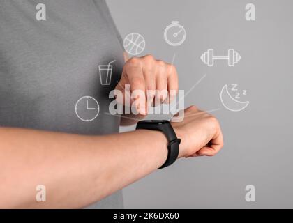 Fitness-Armband auf der Hand mit verschiedenen Symbolen Dienste der Zeit, Alarm, Wasser Erinnerung, Fitnessraum, Puls. Hochwertige Fotos Stockfoto