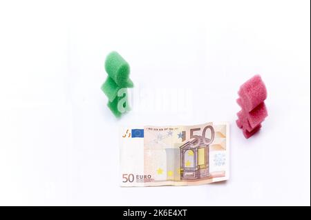 Darstellung von Mann und Frau beim Betrachten einer 50-Euro-Banknote aus Europa zum Konzept der Wirtschaftskrise für Familien. Stockfoto