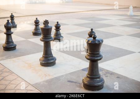 Große Stücke Schachspiele im Park. Straßenspiele.übergroße Schach im Freien auf dem Boden in öffentlichen Bereichen Zone. Selektiver Fokus. Hobby, Freizeit und Stockfoto