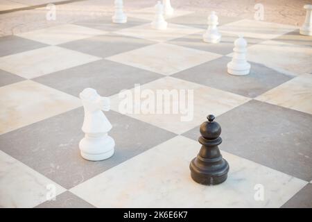 Große Stücke Schachspiele im Park. Straßenspiele.übergroße Schach im Freien auf dem Boden in öffentlichen Bereichen Zone. Selektiver Fokus. Hobby, Freizeit und Stockfoto