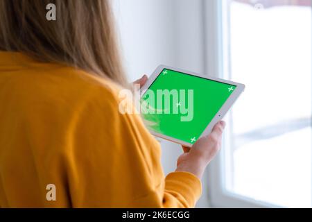 Mädchen mit iPad Tablet Anzeige grünen Bildschirm drücken Browsen Chroma-Taste online eingeben Text lesen Social Media close up Hände 13.12.21 St.Petersburg Stockfoto