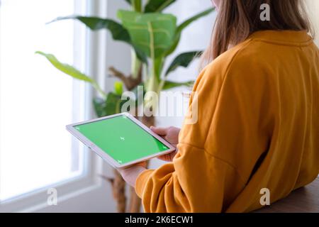 Mädchen mit iPad Tablet Anzeige grünen Bildschirm drücken Browsen Chroma-Taste online eingeben Text lesen Social Media close up Hände 13.12.21 St.Petersburg Stockfoto