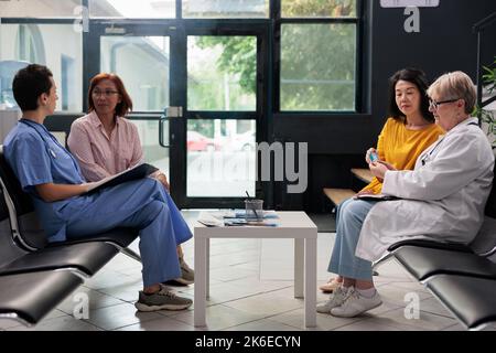 Asiatischer Patient, der eine Diabetesuntersuchung mit dem Glucometer-Instrument macht, Arzt, der den Glukosezuckerspiegel beim Insulintest misst. Blutprobe für diabetische ältere Frau in der Krankenhauslobby prüfen. Stockfoto