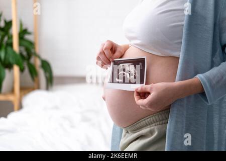 Draufsicht beschnitten von Schwangeren mit Ultraschall-Foto des fgeborenen zu Hause stehen, junge zukünftige Mutter warten Kind erstes Baby, Schwangerschaft und Stockfoto