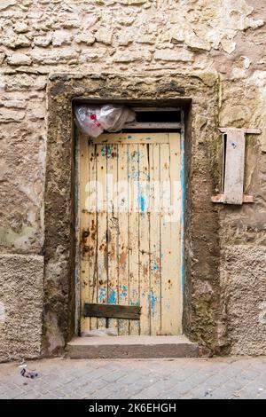 Gelbe und blaue alte bemalte Holztür in Essaouira, Marokko, Nordafrika Stockfoto