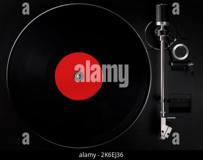 Schwarzer Plattenspieler spielt Vinyl-Schallplatte, leeres Label. Blick von oben auf den altmodischen Plattenspieler. Stockfoto