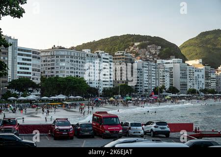 Blick auf den Copacabana Beach am Südende der Küste voller Touristen mit vielen Apartmentgebäuden am Wasser am späten Nachmittag unter sonnigem blauen Himmel. Stockfoto