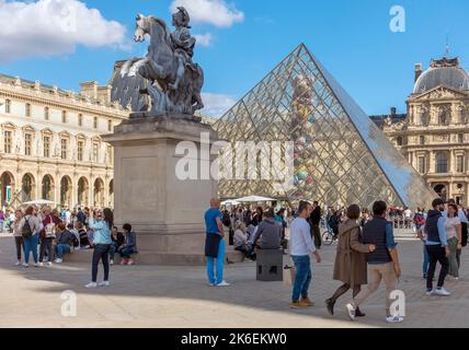 Menschen versammeln sich um die Louvre-Pyramide, Paris, Frankreich Stockfoto