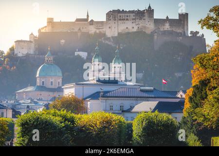 Salzburger Stadtbild bei Sonnenaufgang vom mirabellgarten mit österreichischer Flagge Stockfoto