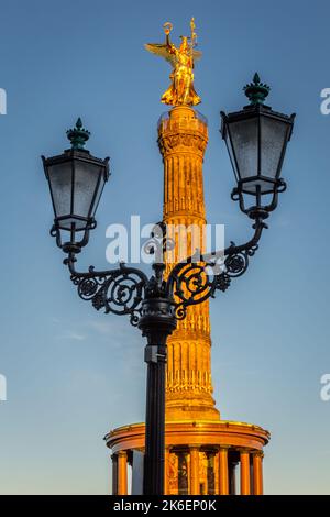 Siegessäule im Berliner Tiergarten bei Sonnenuntergang eingerahmt von Straßenlaterne, Deutschland Stockfoto