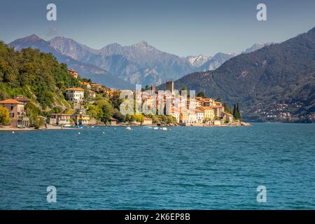 Idyllische Küste am Comer See mit Dorf und Schnellboot an sonnigen Tagen, Italien Stockfoto