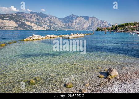 Idyllische Küste am Gardasee in Malcesine mit durchscheinendem Wasser, Italien Stockfoto