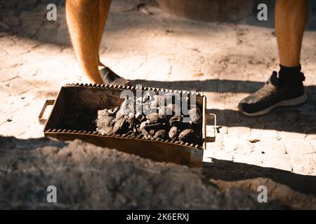 Grill wird bei einem Picknick verwendet, um Fleisch darauf zuzubereiten Stockfoto