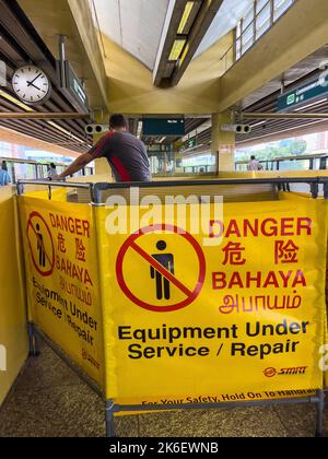 Die Rolltreppe ist wegen Reparaturarbeiten am Bahnhof geschlossen, Gefahrenschilder sind aufgestellt, um die Öffentlichkeit zu informieren. Ein professionelles Servicepersonal ist für die Arbeit da. Stockfoto