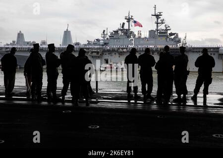 Norfork, Usa. 13. Oktober 2022. USA Marinesoldaten an Bord des amphibischen Sturmschiffs USS Wasp der Wasp-Klasse beobachten von der Hangar Bay aus, wie die USS Kearsarge zur Heimathafen Naval Station Norfolk, 13. Oktober 2022 in Norfork, Virginia, zurückkehrt. Die Kearsarge kehrt von einem siebenmonatigen Einsatz in der Hohen Nord- und Ostsee zurück. Kredit: MC2 Benjamin F. Davella III/US Navy/Alamy Live Nachrichten Stockfoto