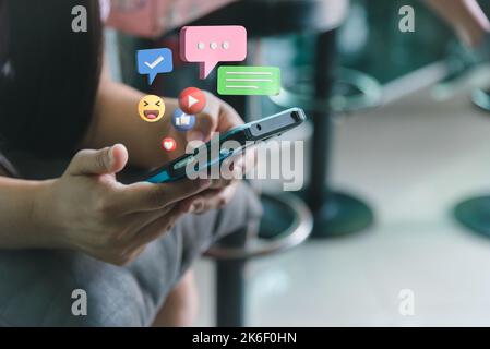 Frau hält mobile Smartphone Social-Media-Symbol und Kommunikation digitale Internet-Marketing-Technologie Geschäftskonzept. Stockfoto